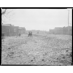 Unpaved road and buildings with car
